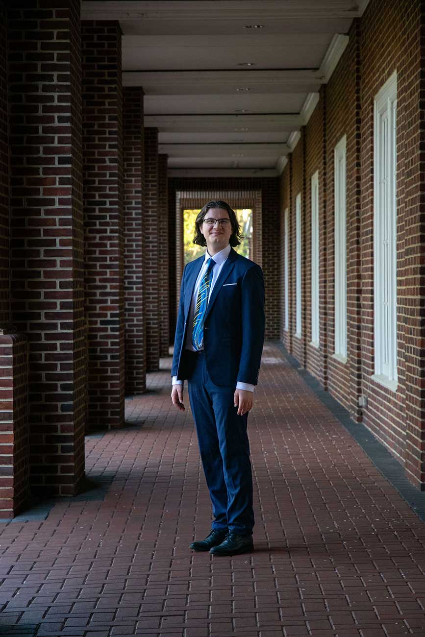 Xander standing in a brick columned outdoor hall before his recital